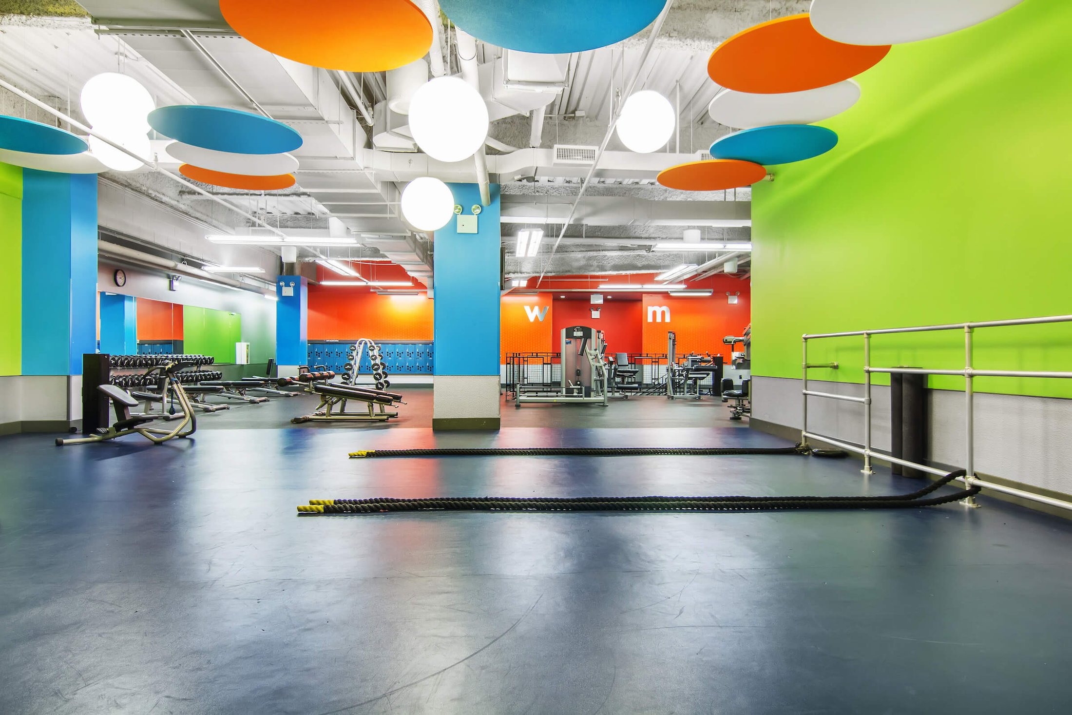 Training floor with colorful ceiling baffles and a turf lane