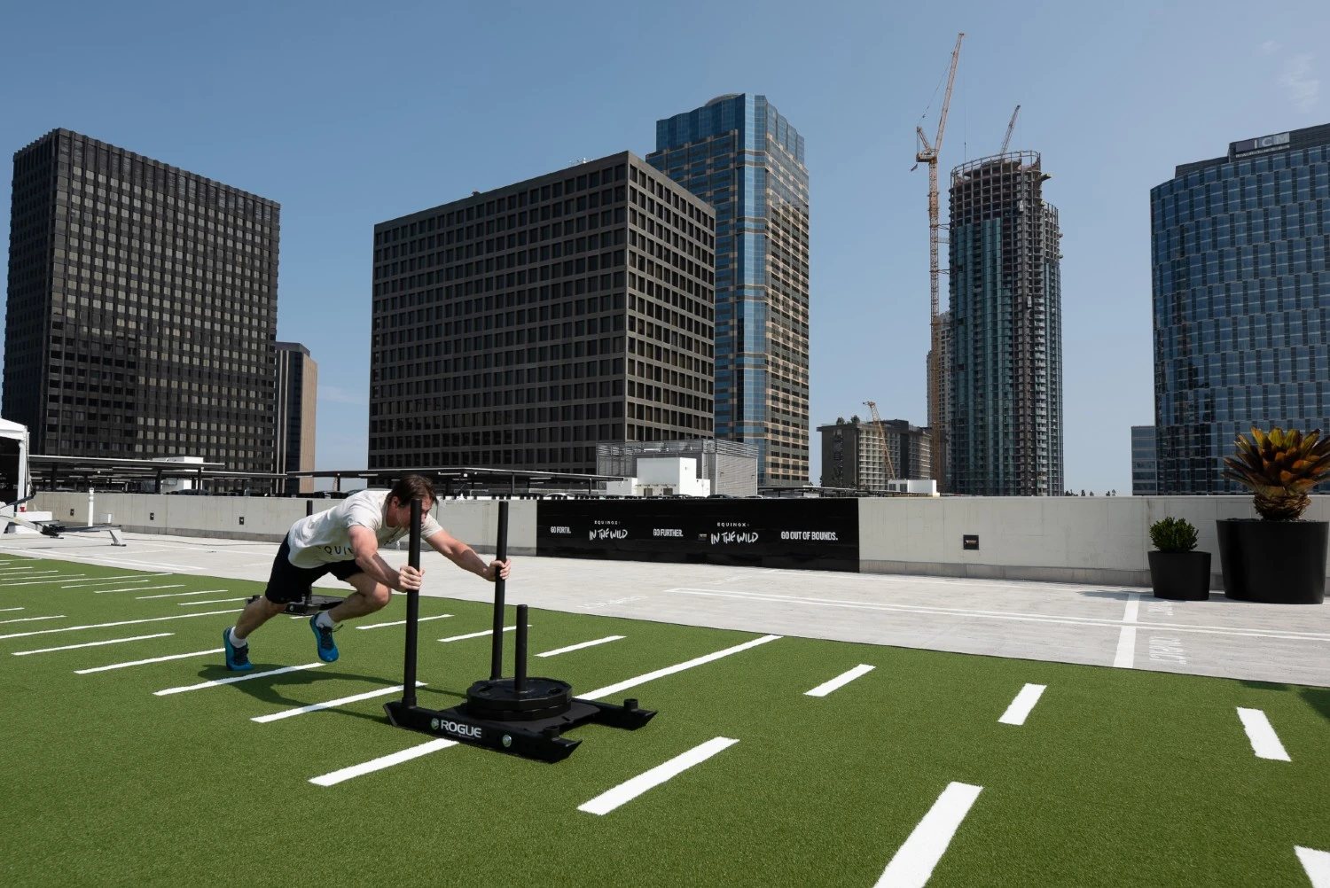 Sled push on rooftop turf above the Century City skyline