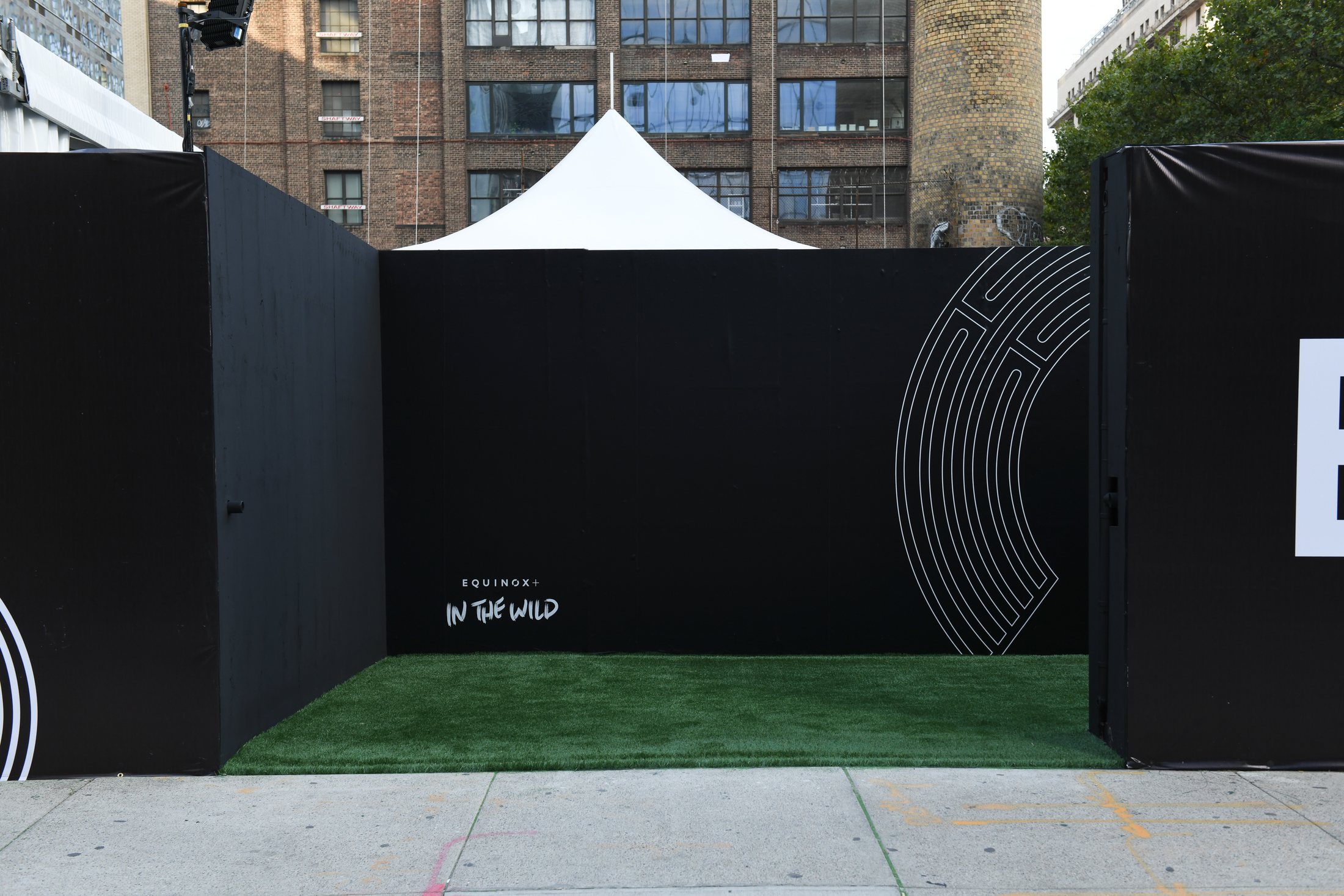 Black branded walls and turf forming the New York entrance