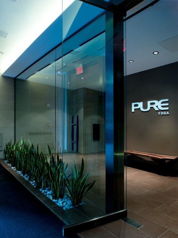Glass entry with PURE signage and a bed of planting