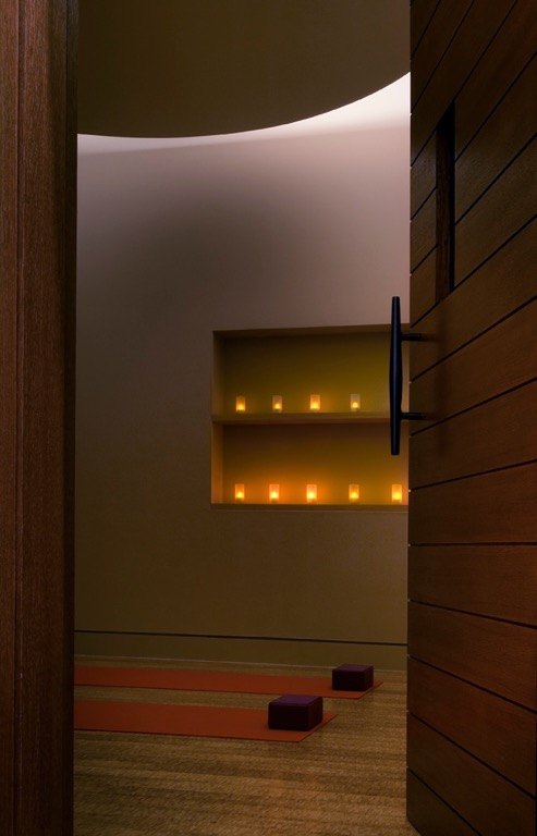 Candle niche glowing beside a curved studio wall
