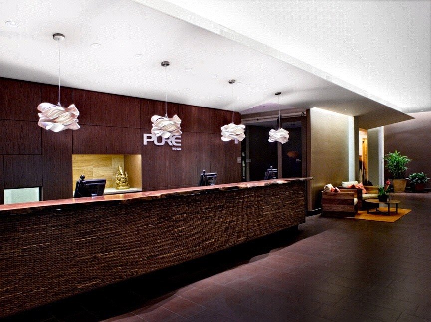 Reception desk in dark wood under sculptural pendant lights