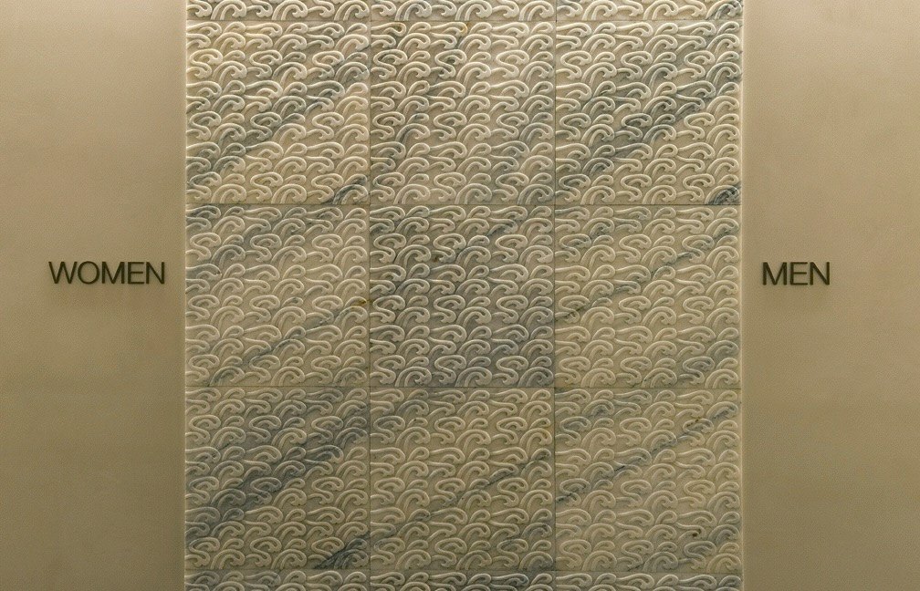 Carved wave-pattern stone marking the women's and men's thresholds
